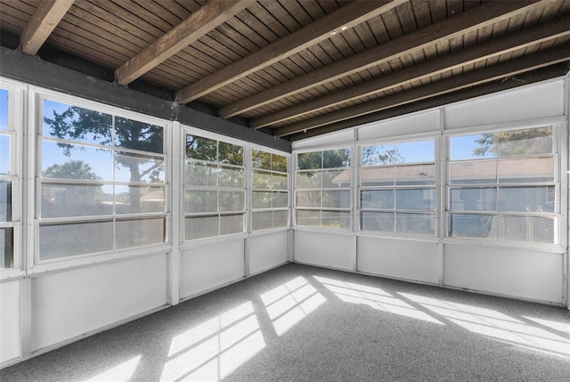 unfurnished sunroom featuring vaulted ceiling with beams, wooden ceiling, and plenty of natural light