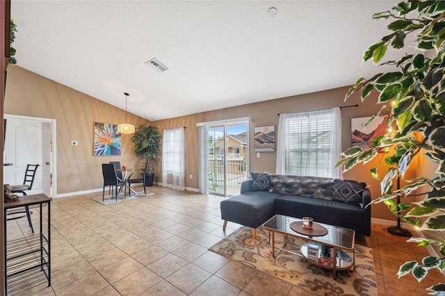 living area with light tile patterned floors, visible vents, plenty of natural light, and lofted ceiling