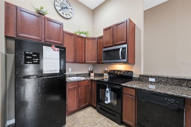 kitchen with light tile patterned floors, black appliances, and dark stone counters