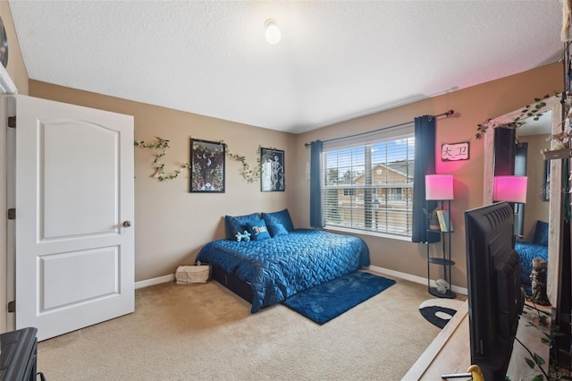 bedroom featuring carpet, baseboards, and a textured ceiling