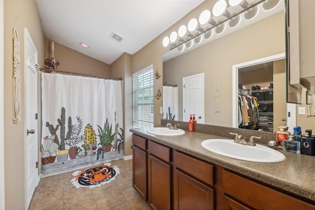 full bathroom with tile patterned flooring, vaulted ceiling, visible vents, and a sink