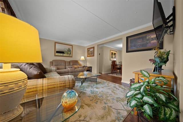 living room with baseboards, wood finished floors, and ornamental molding