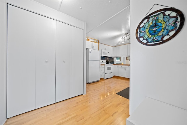 kitchen featuring white cabinetry, white appliances, and light wood-style flooring