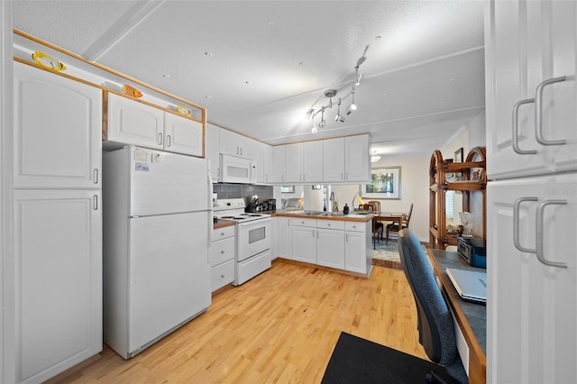 kitchen with light wood-type flooring, a sink, tasteful backsplash, white cabinetry, and white appliances