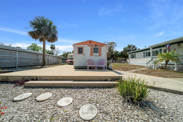 back of property featuring an outbuilding and fence