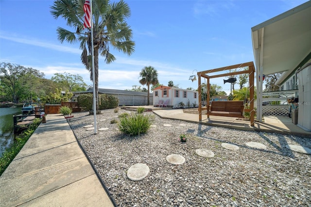 view of yard with a patio area, a pergola, an outdoor structure, and fence