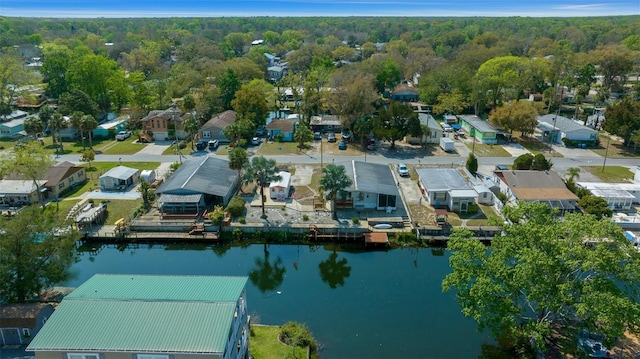 drone / aerial view with a forest view, a residential view, and a water view