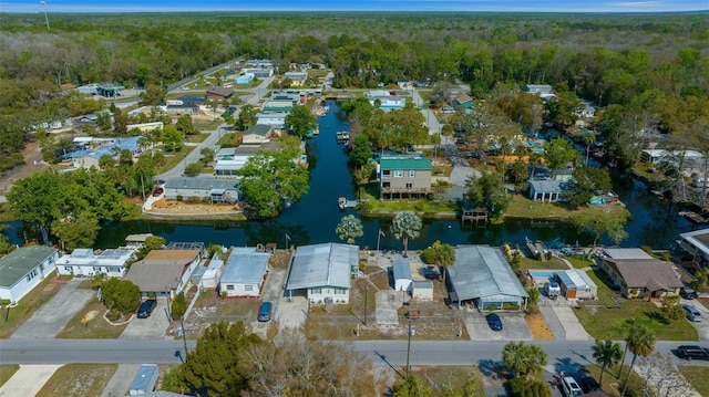 aerial view with a forest view, a residential view, and a water view