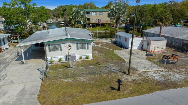 6448 W Richard Dr, Weeki Wachee, FL 34607 - view of front of home with a fenced backyard, driveway, an outbuilding, and a shed