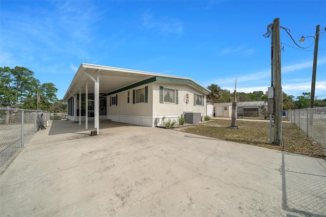 6448 W Richard Dr, Weeki Wachee, FL 34607 - manufactured / mobile home with a storage shed, an attached carport, cooling unit, concrete driveway, and fence