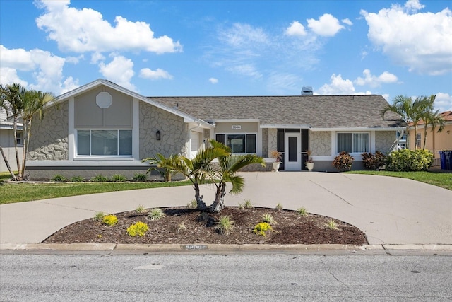 view of front of property with a garage, stone siding, driveway, and a shingled roof