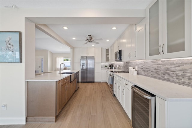 kitchen featuring a sink, tasteful backsplash, appliances with stainless steel finishes, and beverage cooler