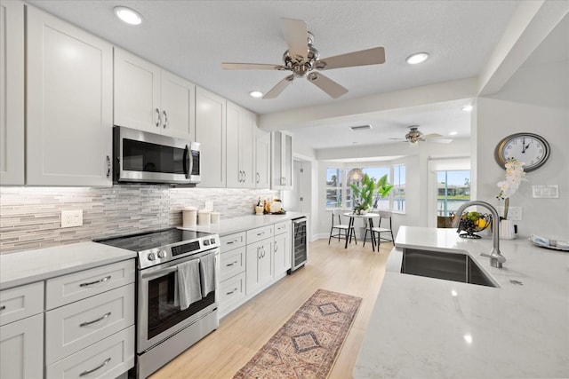 5000 Galleon Ct, New Port Richey, FL 34652 - kitchen featuring stainless steel appliances, backsplash, ceiling fan, white cabinets, and recessed lighting