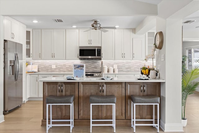 5000 Galleon Ct, New Port Richey, FL 34652 - kitchen with stainless steel appliances, white cabinetry, backsplash, and recessed lighting