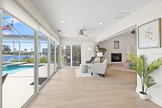 5000 Galleon Ct, New Port Richey, FL 34652 - sunroom with a glass covered fireplace and a ceiling fan
