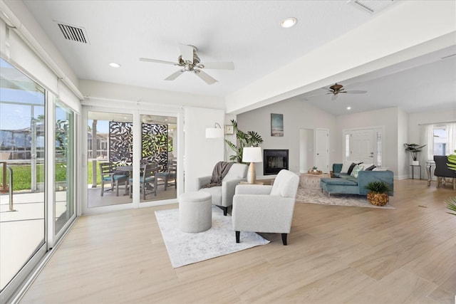 5000 Galleon Ct, New Port Richey, FL 34652 - living room featuring a ceiling fan, a glass covered fireplace, light wood-type flooring, recessed lighting, and vaulted ceiling