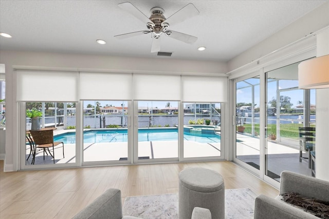 5000 Galleon Ct, New Port Richey, FL 34652 - view of swimming pool with a pool with connected hot tub, a water view, and ceiling fan