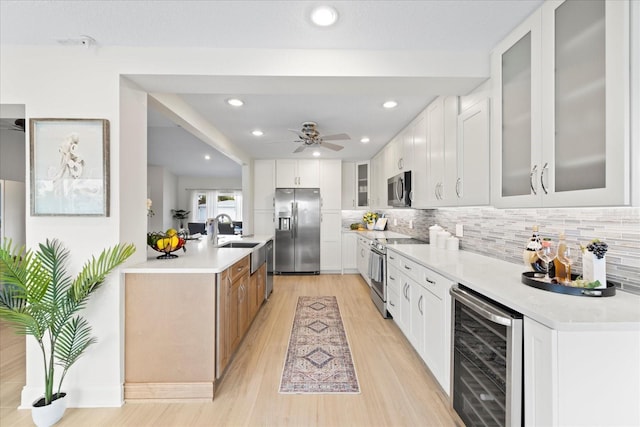 5000 Galleon Ct, New Port Richey, FL 34652 - kitchen featuring stainless steel appliances, wine cooler, light wood-style flooring, decorative backsplash, and glass insert cabinets
