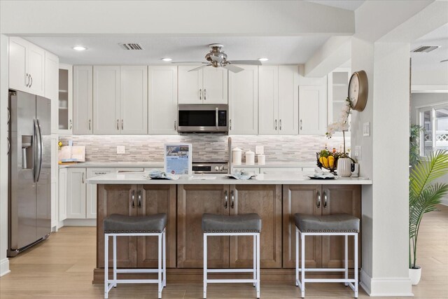 5000 Galleon Ct, New Port Richey, FL 34652 - kitchen with stainless steel appliances, white cabinetry, backsplash, and recessed lighting