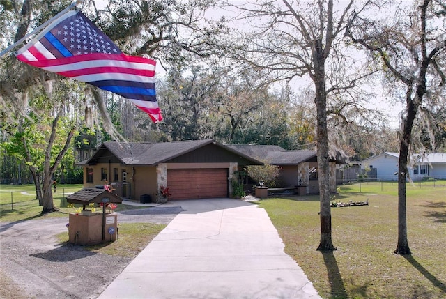 view of front of home with an attached garage, driveway, fence, and a front lawn