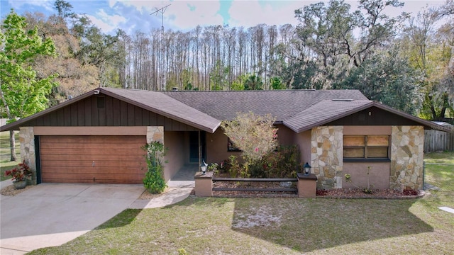 view of front of home with driveway, stone siding, a garage, and a front lawn