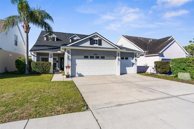 view of front of property featuring an attached garage, a shingled roof, driveway, and a front yard