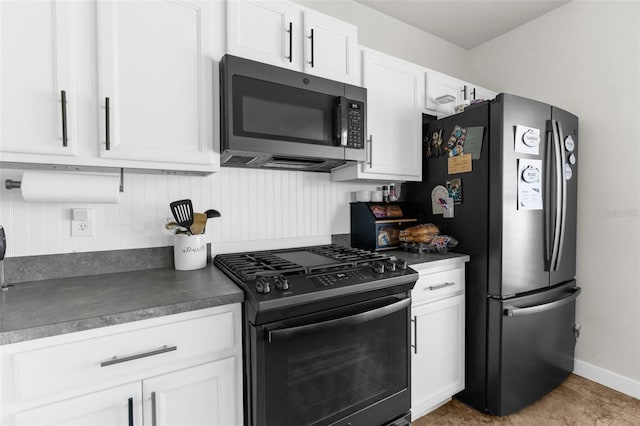 kitchen featuring stainless steel appliances, baseboards, dark countertops, and white cabinets