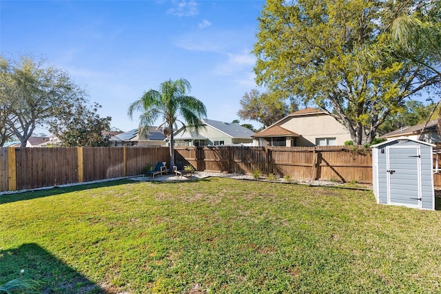 view of yard with a storage shed, a fenced backyard, an outdoor structure, and a patio