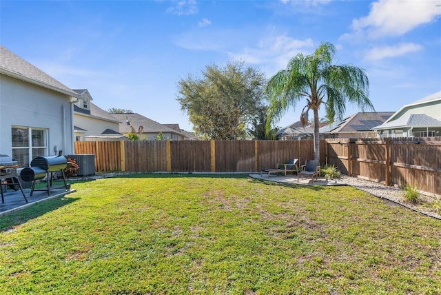 view of yard featuring a fenced backyard, central AC unit, and a patio