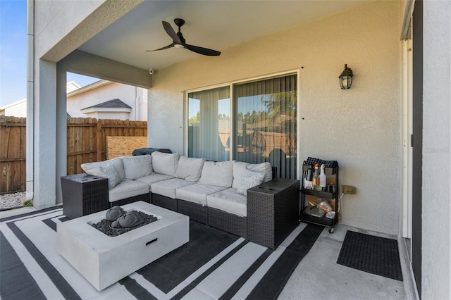 view of patio featuring a ceiling fan, fence, and an outdoor living space with a fire pit