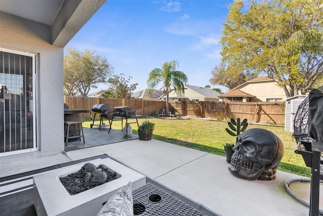 view of patio / terrace with an outbuilding, a shed, a fire pit, and a fenced backyard