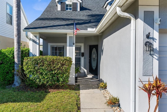 property entrance featuring stucco siding and roof with shingles