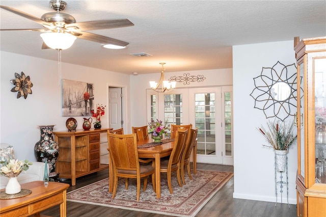 dining room featuring dark wood-style floors, visible vents, a textured ceiling, and french doors