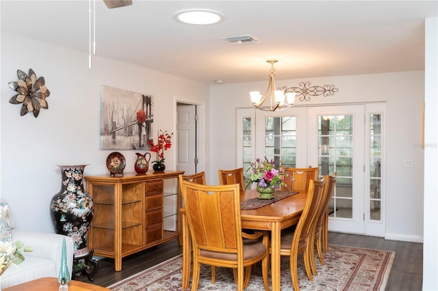 dining room with a notable chandelier, visible vents, and dark wood-type flooring