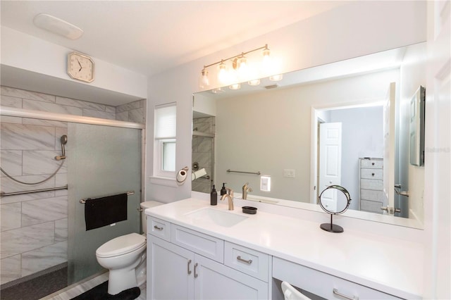 bathroom featuring a stall shower, vanity, and toilet