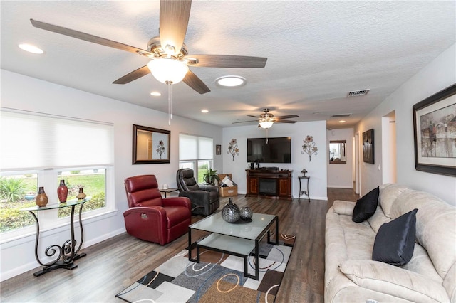 living room with dark wood-style floors, visible vents, and a textured ceiling