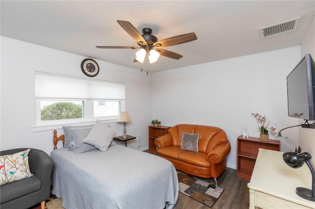 bedroom with visible vents, ceiling fan, a textured ceiling, wood finished floors, and baseboards