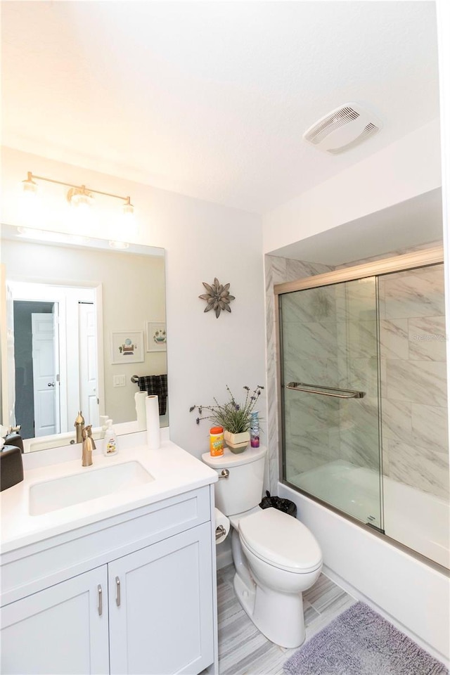 full bathroom with toilet, enclosed tub / shower combo, visible vents, and vanity