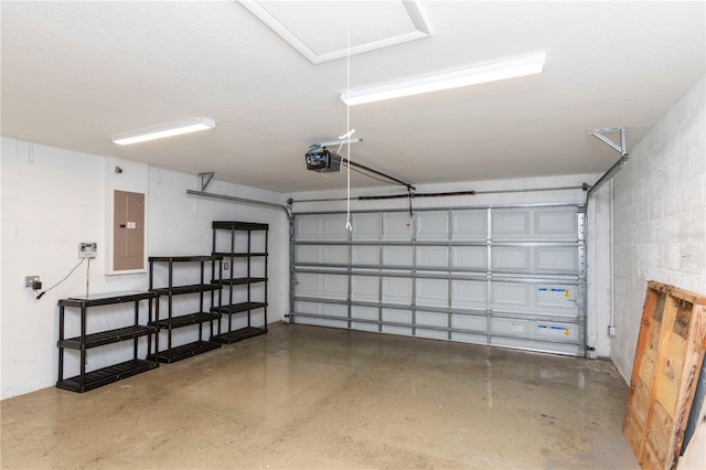 garage featuring a garage door opener, concrete block wall, and electric panel