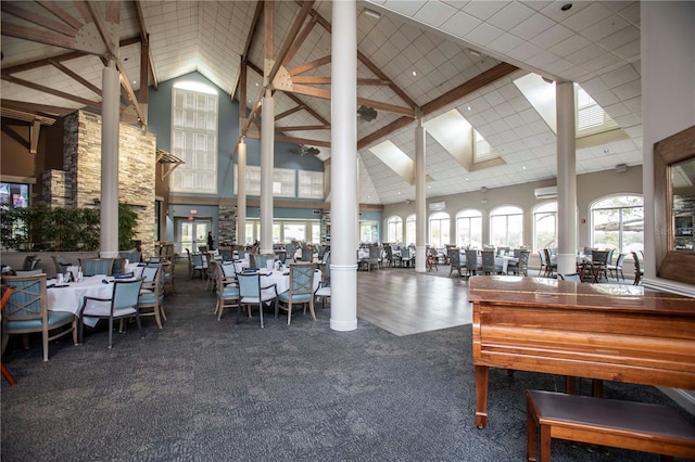 unfurnished dining area featuring high vaulted ceiling, carpet, and ornate columns