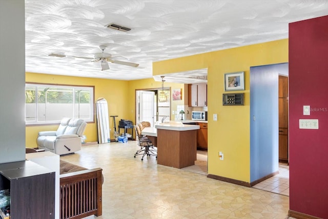 5441 Alderwood St, Spring Hill, FL 34606 - kitchen with a breakfast bar area, light countertops, visible vents, hanging light fixtures, and open floor plan
