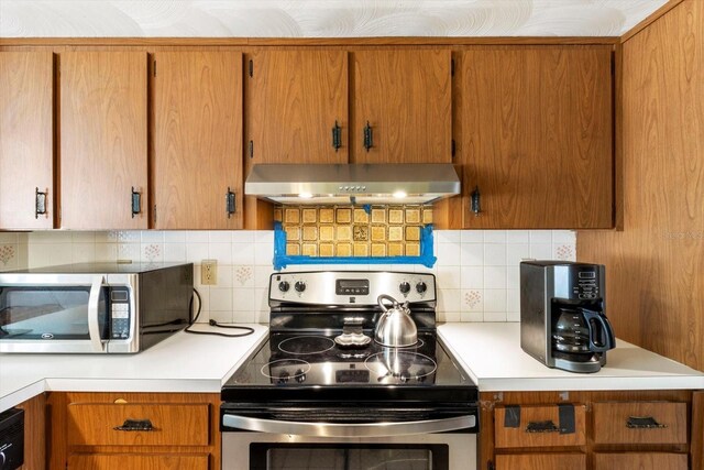 5441 Alderwood St, Spring Hill, FL 34606 - kitchen with stainless steel appliances, light countertops, decorative backsplash, brown cabinetry, and exhaust hood