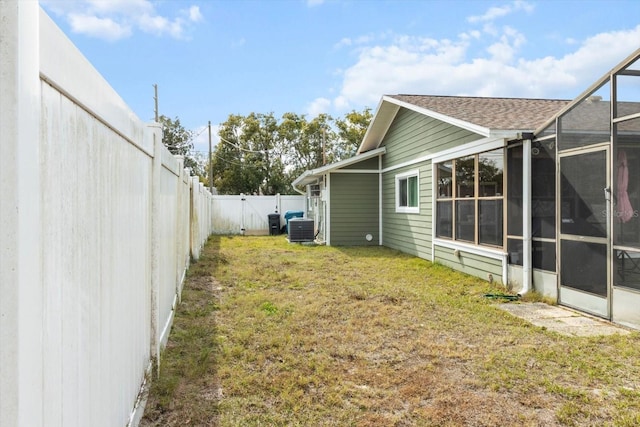 5441 Alderwood St, Spring Hill, FL 34606 - view of yard with glass enclosure, central AC unit, and a fenced backyard