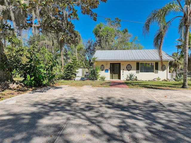 view of front of house featuring stucco siding and metal roof