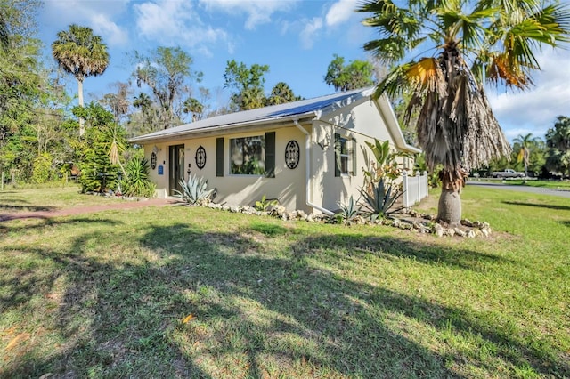 view of front facade with stucco siding and a front yard