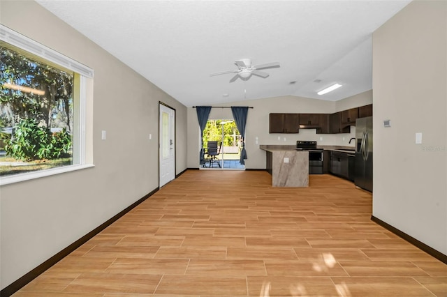 kitchen featuring wood finish floors, a ceiling fan, under cabinet range hood, a kitchen island, and appliances with stainless steel finishes