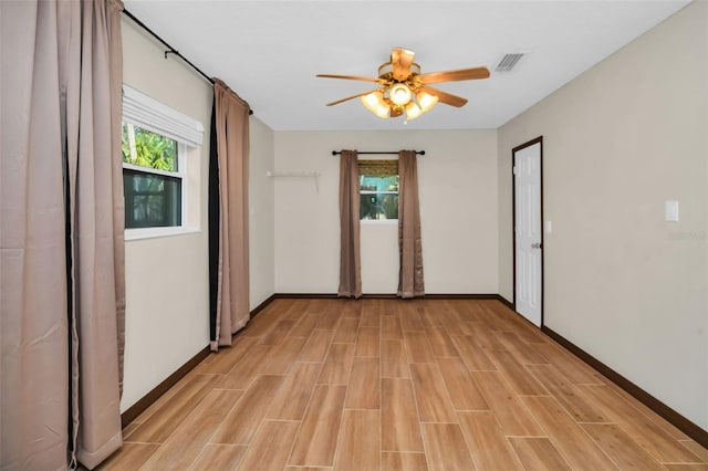 unfurnished room with baseboards, a ceiling fan, visible vents, and wood finish floors