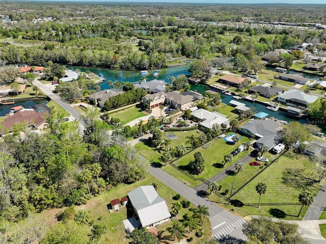 aerial view featuring a residential view, a water view, and a view of trees