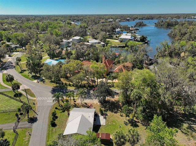 birds eye view of property with a view of trees and a water view