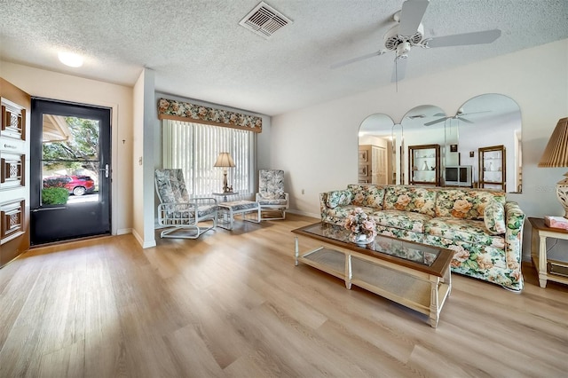 living room featuring plenty of natural light, visible vents, and wood finished floors